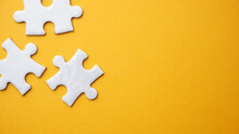 White Jigsaw Puzzle Pieces In Yellow Background
