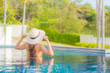 © siraphol - Portrait beautiful young asian woman relax smile leisure around outdoor swimming pool
