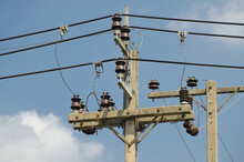 Electrical Insulators Set With Transmission Lines On Background Of Sky And Clouds
