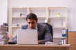 © Elnur - Young male employee unhappy with excessive work in the office