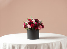 Red, Pink And Dark Red Roses Bouquet In A Black Box On A White Table And Pink Backround