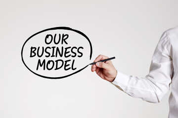 Businessman writes the word our business model with an outline circle