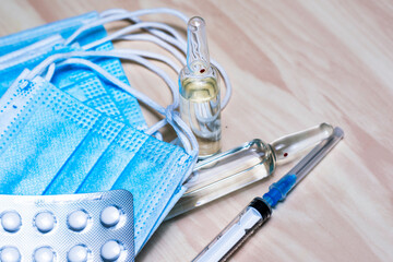 Wall Mural - a syringe tablets in blisters medical hygiene masks and ampoules with medicines on the table