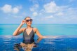 © siraphol - Portrait beautiful young asian woman relax smile leisure around outdoor swimming pool