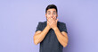 © luismolinero - Caucasian handsome man covering mouth with hands over isolated purple background