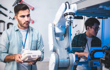 Wall Mural - Male Engineers Maintenance Robot Arm at Lab. he are in a High Tech Research Laboratory with Modern Equipment.Professional Japanese Development Engineer is Testing an Artificial Intelligence.