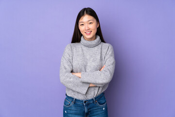 Wall Mural - Young asian woman over isolated background keeping the arms crossed in frontal position