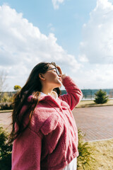 Wall Mural - Portrait of young cheerful caucasian woman walking in the park and having fun, enjoying spring weather in sunny day.