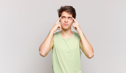 Wall Mural - young boy looking concentrated and thinking hard on an idea, imagining a solution to a challenge or problem