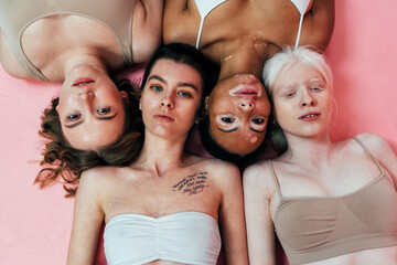 group of multiethnic women with different kind of skin posing together in studio. concept about body