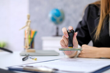 Close up of businesswoman hand stamping with approve document at the office.