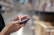 © DG PhotoStock - Woman using a smartphone when shopping in the store.