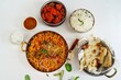 Indian Non veg meal Chicken biryani Roti Chilli chicken rice salan and Raita isolated on white