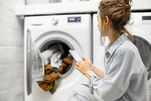 Woman Controls Washing Machine With A Smartphone
