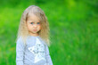 © Olena - Close up little blonde girl of four 4 years old sulking outdoors in summer. Sad cute vulnerable offended kid with big blue eyes on blurred green background. Children Protection Day. Hopeful concept