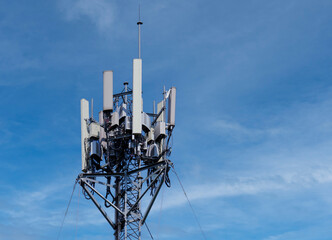 Wall Mural - Telecommunication tower of 4G and 5G cellular. Macro Base Station. 5G radio network telecommunication equipment with radio modules and smart antennas mounted on a metal against blue sky background.