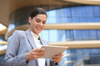 © ty - Business woman at work with tablet near office outdoors.
