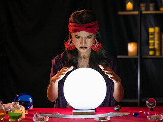 Asian fortune teller looking at crystal ball