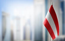A small flag of Austria on the background of a blurred background