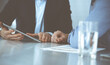 © Iryna - Business people using tablet computer while working together at the desk in modern office. Unknown businessman or male entrepreneur with colleague at workplace. Teamwork and partnership concept