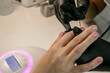 © Ilia Petukhov - Nail treatment in a beauty salon. Application of the final coat of varnish.