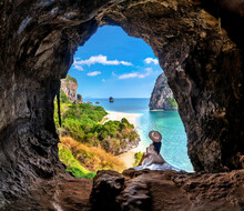 Woman Sitting In The Cave At Railay, Krabi, Thailand.