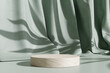 Leinwandbild Motiv Wooden product display podium stand with shadow nature leaves on green curtain background. 3D rendering