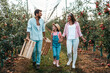 © hedgehog94 - Happy family enjoying together while picking apples in orchard.
