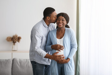 Wall Mural - Loving black man kissing his pregnant wife