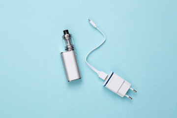 Vaping device with charger on blue background