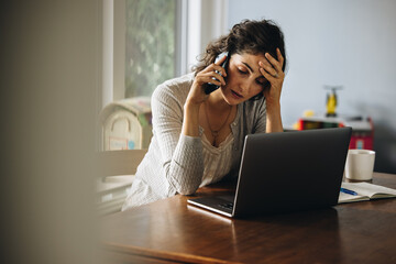 Disappointed businesswoman at home talking on phone