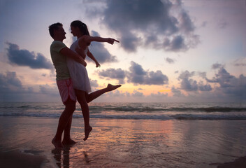 Wall Mural - The image of silhouette of two people in love at sunset in Thailand