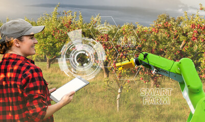 Aufkleber - A farmer controls a robot arm in an apple orchard. Agriculture industry concept.