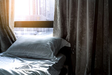 White Comfort Bed And Soft Pillow In Modern Bedroom. Bed Near Window And Curtain At Hotel.