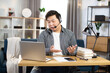 © Sofiia Shunkina - Asian man using headset and laptop for video chat