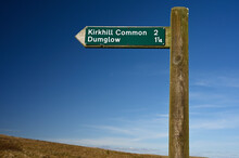 Public Sign For Kirkhill Common And Dumglow. At Loch Glow, Cleish Hills, Fife, Scotland. Sunny Day With Blue Sky. Slope Of Moorland Hill Blurred In Background.