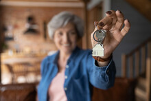 House Of Dream. Blurred Portrait Of Happy Elderly Female Of Senior Age Becoming Landlord Homeowner Pose In Modern Country Cottage Hold Bunch Of Keys Celebrate Moving Day. Focus On Key In Old Lady Hand