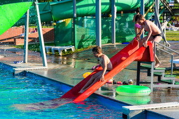 Children's entertainment in the pool, a fun descent from the slide into the pool with water.