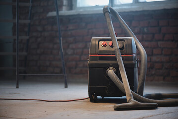 Wall Mural - Industrial vacuum cleaner on the dusty floor of construction site.