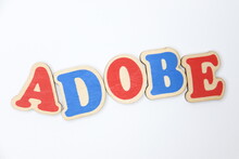 The Word "adobe" Made Of Colored Wooden Letters On A White Background.