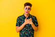 © Asier - Young caucasian man wearing a Hawaiian shirt isolated on yellow background has friendly expression, pressing palm to chest. Love concept.