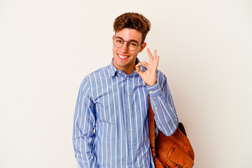 Young student man isolated on white background winks an eye and holds an okay gesture with hand.