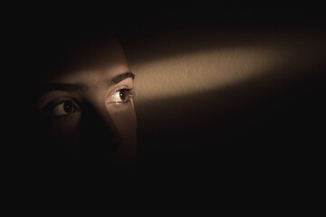 Single ray of light falling over girls eyes