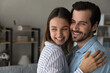 © fizkes - Close up happy young couple family hugging, visualizing good future, looking to aside, standing at home, smiling excited wife and husband dreaming about new opportunities, planning together