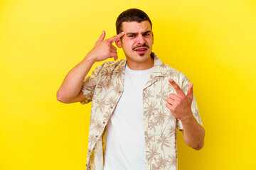 Young caucasian cool man isolated on yellow background showing a disappointment gesture with forefinger.