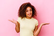 © Asier - Young african american woman isolated on pink background confused and doubtful shrugging shoulders to hold a copy space.