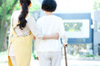 シニア女性の歩行を介助する女性介護士の後ろ姿