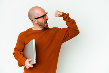 Young bald man holding a laptop isolated on white background raising fist after a victory, winner concept.