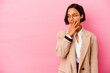 © Asier - Young business mixed race woman isolated on pink background thoughtful looking to a copy space covering mouth with hand.