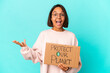 © Asier - Young hispanic mixed race woman holding a protect our planet cardboard receiving a pleasant surprise, excited and raising hands.